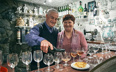 A couple pouring drinks for guests during an excursion to their home